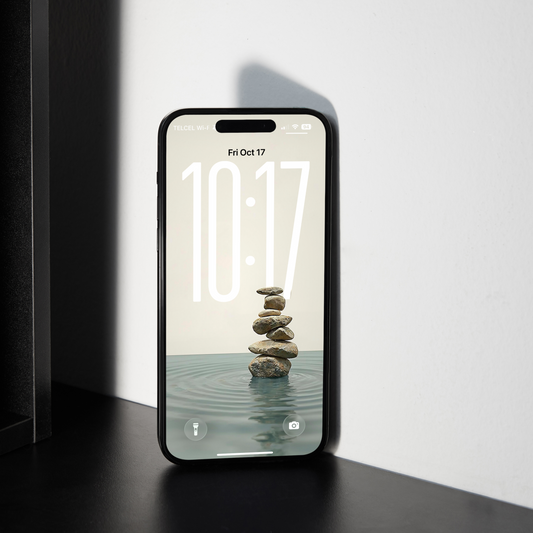 Smartphone displaying a screen with stones in water on a black surface.