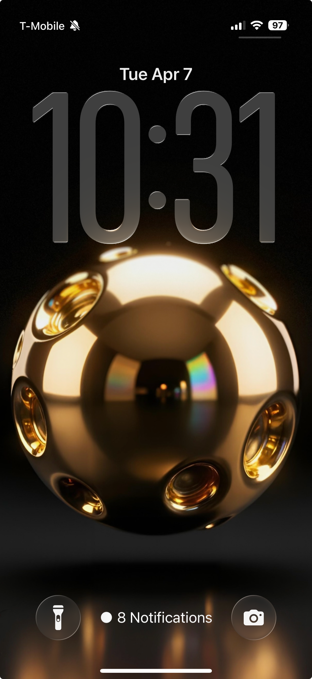 Phone screen displaying a gold sphere with a T-Mobile logo, time 10:31, and date Tuesday, April 7.