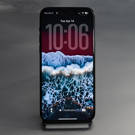 Phone on a studio stand displaying blue ocean surf with white foam below a deep crimson upper background.