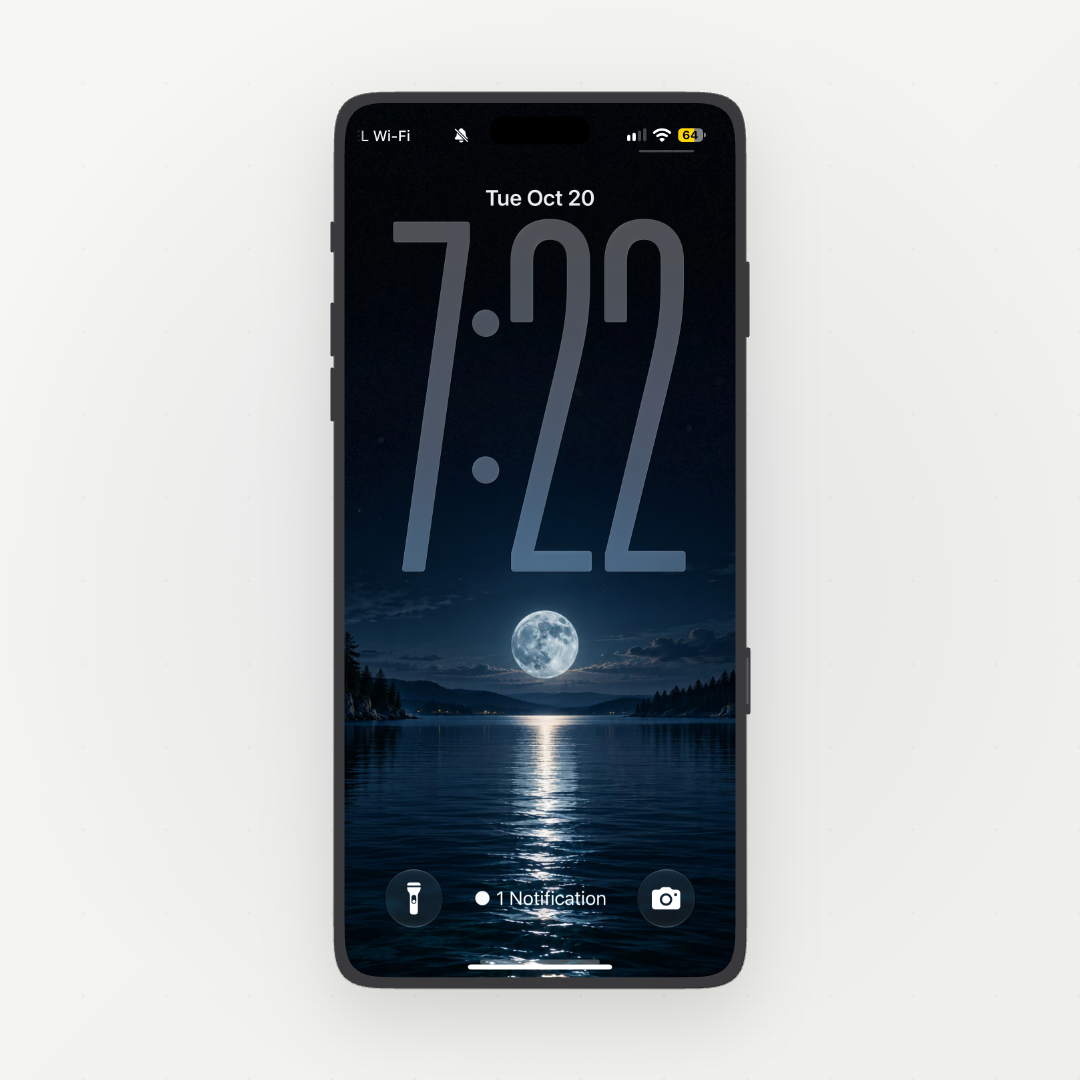 Front-facing phone displaying a full moon reflected in a dark blue lake between forested shores.