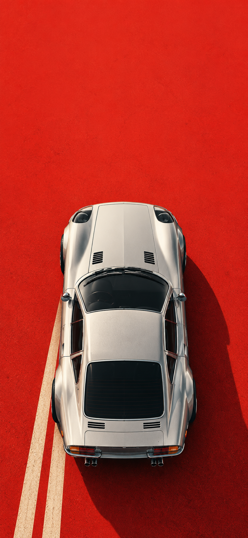 Wallpaper preview featuring a silver classic sports car viewed from above on a red road with cream stripes.